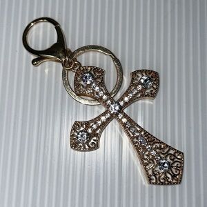 Gold tone rhinestone covered filigree cross keychain